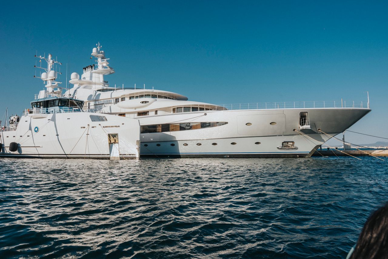 services-02 A majestic luxury yacht docked on serene waters under a clear blue sky, exemplifying nautical elegance.